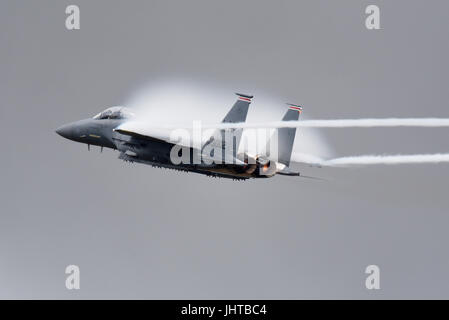 Avion de chasse McDonnell Douglas Boeing F-15 Eagle de la RAF Lakenheath effectuant une démonstration de force à grande vitesse lors d'un spectacle aérien créant un nuage d'humidité à partir de la pression de l'air comprimé Banque D'Images