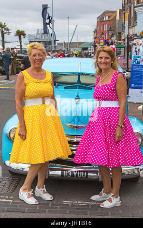 Poole va Vintage, Poole, Dorset, UK. 16 juillet 2017. Poole va Vintage événement a lieu sur le quai - les visiteurs s'habillent en vêtements vintage. Mesdames dans polka dot robes posent devant Chevrolet fleetline voiture. Credit : Carolyn Jenkins/Alamy Live News Banque D'Images