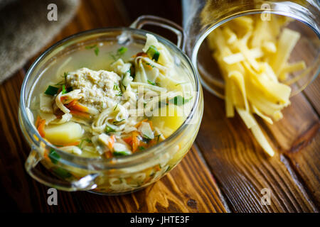 Soupe avec des nouilles et des boulettes de viande dans un bol en verre Banque D'Images