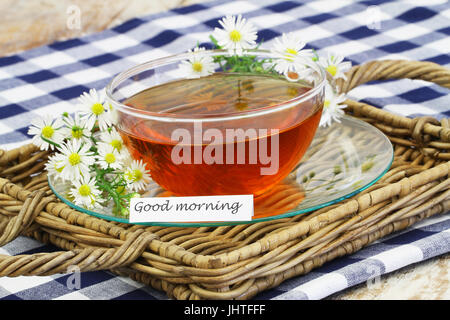 Bonjour carte avec tasse de thé et des fleurs de camomille Banque D'Images