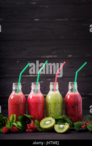 Frais sain des smoothies de fruits différents sur un fond sombre Banque D'Images