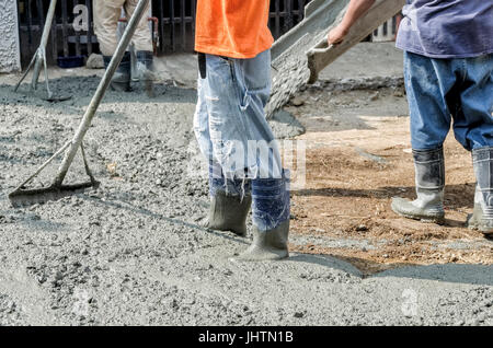 Les hommes de la construction en béton coulé récemment mise à niveau mix on road Banque D'Images