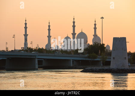 Vue de la mosquée Blanche célèbre Sheikh Zayed à Abu Dhabi, eau de la mer au coucher du soleil Banque D'Images