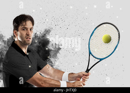 Joueur de tennis avec un uniforme noir qui sort d'une explosion de fumée . Banque D'Images