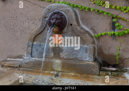 L'eau de source ancienne fontaine dans la Rue de porche, Grimaud, France Banque D'Images
