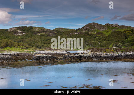 Péninsule de Assynt, ÉCOSSE - 7 juin 2012 : rough Green Hills et le bleu de l'océan Atlantique au sud de l'entrée d'eaux de Loch Une Arbhair. Le bleu ciel nuageux. Banque D'Images