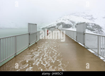 Sur le dessus de l'un des murs du barrage du réservoir de Silvretta lac près de Galtur Autriche, avec de la neige au milieu de l'été. Banque D'Images