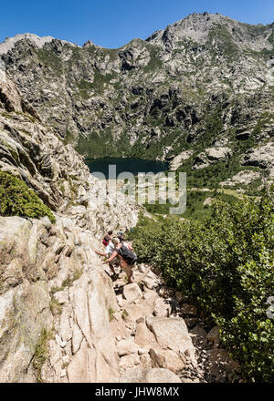 LAC DE MELO, PRÈS DE CORTE, CORSE - juillet 2017. Les randonneurs sur le sentier rocheux entre le lac de Capitello et lac de Melo en Corse sur une journée de juillet ensoleillé Banque D'Images