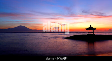 Silhouette d'une pagode balinais sur la plage de Sanur, Bali. Lumière du matin avant le lever du soleil à la recherche sur l'océan avec le Mt Agung en arrière-plan. Banque D'Images