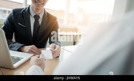 Jeune homme d'affaires à l'entrevue d'embauche dans le bureau, réunion au hall de l'office, l'évolution des cartes d'affaires Banque D'Images