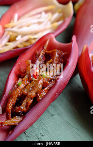 La transformation des aliments végétariens de fleur de bananier, rouler les jeunes fruits banane avec la farine puis fry et recouvrir de sauce de soja, le sucre et le piment, nourriture vegan Banque D'Images