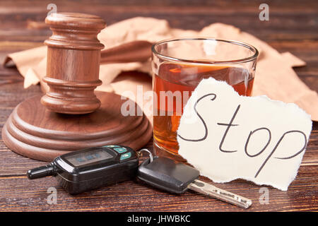 Marteau, clés de voiture, verre d'alcool. Banque D'Images