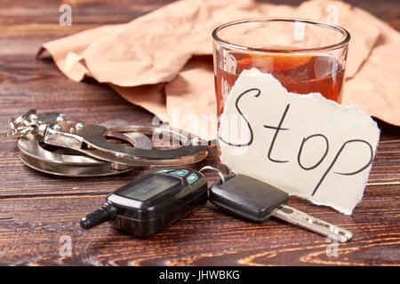 Whisky avec des clés de voiture et des menottes. Banque D'Images