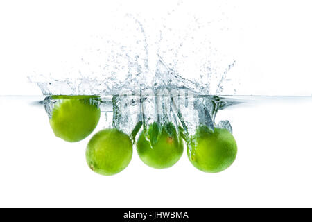 Lime douce largué dans l'eau avec de l'eau splash sur un fond blanc Banque D'Images