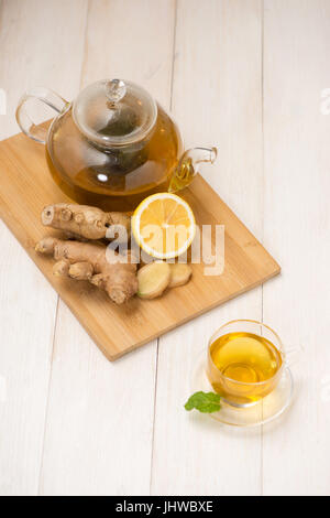 Tasse de thé au gingembre avec du citron et du miel sur fond de bois blanc. Banque D'Images