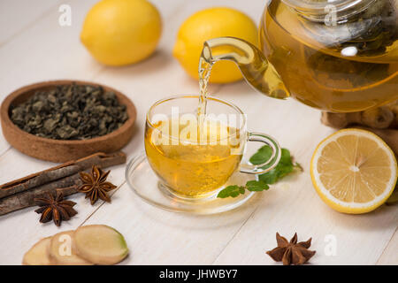 Tasse de thé au gingembre avec du citron et du miel sur fond de bois blanc. Banque D'Images