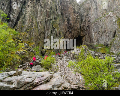 Les touristes au niveau du trou dans la montagne sur le granit Torghatten archipel Treana Brønnøy Municipalité du comté de Nordland en Norvège Banque D'Images