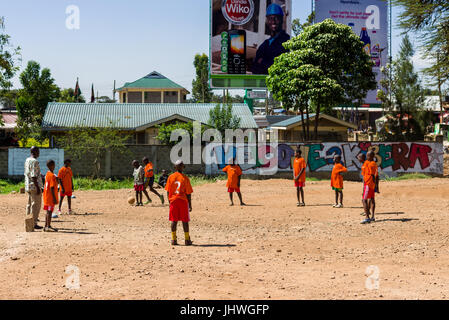 Les enfants de Kibera à jouer au football sur un terrain poussiéreux, Nairobi, Kenya Banque D'Images