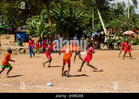 Les enfants de Kibera à jouer au football sur un terrain poussiéreux, Nairobi, Kenya Banque D'Images