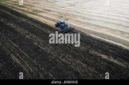 Cultiver du tracteur au champ du printemps, vue aérienne Banque D'Images