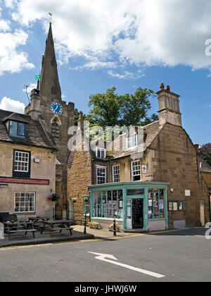 Vieux bâtiments en pierre, pub, pharmacie et église de St Peter et St Paul, Uppingham Market place, Rutland, Angleterre, Royaume-Uni. Banque D'Images