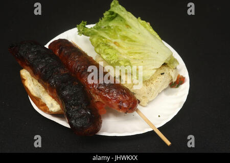 Chorizo grillé sur un petit pain avec de la laitue, cure-dents, et plaques de papier Banque D'Images