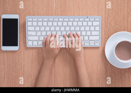 Les mains de l'enfant de taper au clavier dans le bureau Banque D'Images