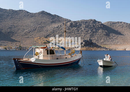 L'île de Symi, sud de la mer Egée, Grèce - un pêcheur réparant ses filets à Pedi Banque D'Images