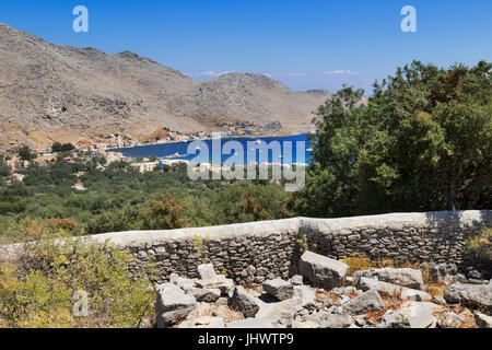 L'île de Symi, sud de la mer Egée, Grèce - la vue de la baie de Pedi Drakos, les vestiges d'une ancienne fortification dans les collines Banque D'Images