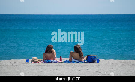 Deux femmes en train de bronzer sur une plage de Floride à serviettes Banque D'Images