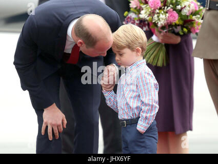 Prince George qui tient la main de son père, le duc de Cambridge, comme il arrive à l'aéroport Chopin de Varsovie avec la duchesse de Cambridge et de la princesse Charlotte pour le début de leur tournée de cinq jours en Pologne et l'Allemagne. Banque D'Images