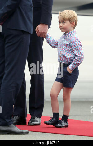 Prince George qui tient la main de son père, le duc de Cambridge, comme il arrive à l'aéroport Chopin de Varsovie avec la duchesse de Cambridge et de la princesse Charlotte pour le début de leur tournée de cinq jours en Pologne et l'Allemagne. Banque D'Images