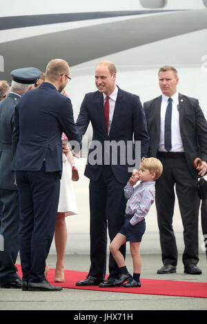 Baisers de Prince George qui tient la main de son père, le duc de Cambridge, comme il arrive à l'aéroport Chopin de Varsovie avec la duchesse de Cambridge et de la princesse Charlotte pour le début de leur tournée de cinq jours en Pologne et l'Allemagne. Banque D'Images
