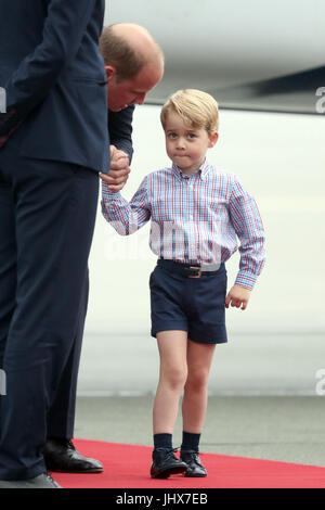 Prince George qui tient la main de son père, le duc de Cambridge, comme il arrive à l'aéroport Chopin de Varsovie avec la duchesse de Cambridge et de la princesse Charlotte pour le début de leur tournée de cinq jours en Pologne et l'Allemagne. Banque D'Images