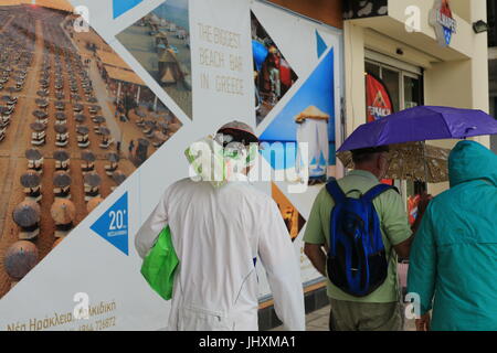 Thessalonique, Grèce. Jul 17, 2017. Les touristes à pied passer une publicité billboad un bar de plage. La tempête qui a été balayé la Grèce a laissé mort d'un homme et a causé plusieurs dommages sur l'ensemble du pays. La neige est tombée sur le mont Olympe et les températures ont chuté à des célibataires chiffres dans certains endroits. Credit : Orhan Tsolak/Alamy Live News Banque D'Images