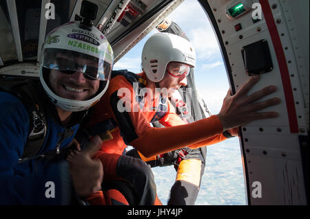 Un étudiant de parachutisme se préparer à quitter l'avion avec deux instructeurs Banque D'Images