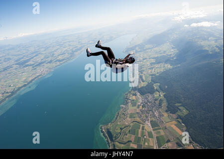 Une femme faisant un amusant skydive au-dessus le lac de Neuchâtel en Suisse Banque D'Images