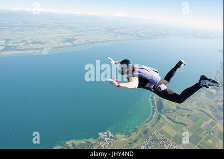 Une femme faisant un amusant skydive au-dessus le lac de Neuchâtel en Suisse Banque D'Images