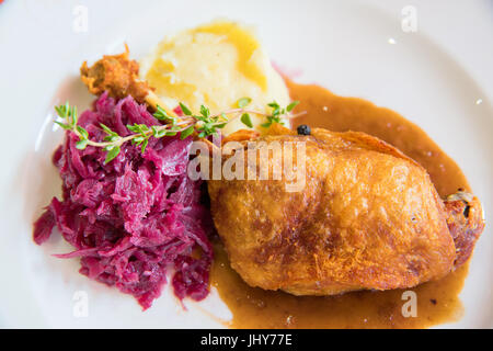 Confit de canard avec purée de pommes de terre et chou mauve on white plate Banque D'Images