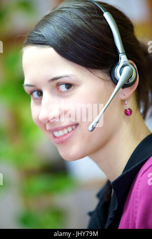 Jeune femme avec casque au bureau - Jeune femme avec casque, Junge Frau mit im Büro Casque - Jeune femme avec casque Banque D'Images