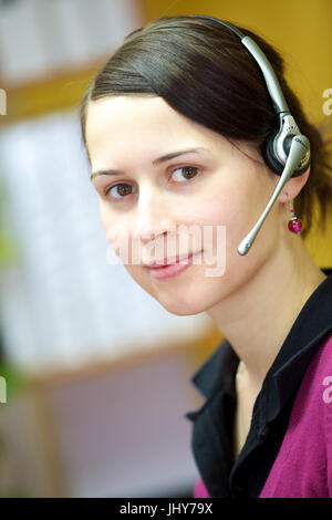 Jeune femme avec casque au bureau - Jeune femme avec casque, Junge Frau mit im Büro Casque - Jeune femme avec casque Banque D'Images