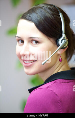 Jeune femme avec casque au bureau - Jeune femme avec casque, Junge Frau mit im Büro Casque - Jeune femme avec casque Banque D'Images