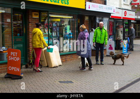 Un petit groupe d'amoureux des animaux avec leurs chiens rencontrer et discuter à l'extérieur de l'animalerie locale à Hythe, dans le Hampshire, sur la côte sud de l'Angleterre Banque D'Images