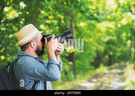 Sac à dos homme photographe avec appareil photo et prendre une photo. Passe-temps de vie voyage aventure en plein air vacances active concept Banque D'Images