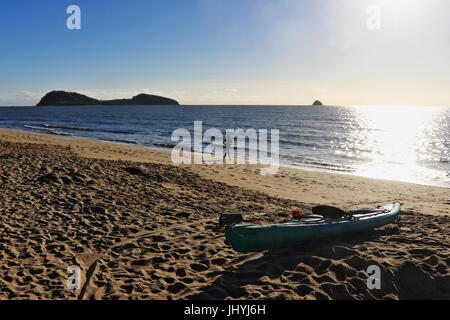 Haut de la plage sur un matin d'hiver à l'extérieur au-delà du kayak bleu et de l'autre côté de la mer de Corail chatoyant vers Double Island et le chapeau Scout Banque D'Images