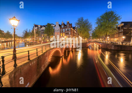 Crépuscule sur feux de bâtiments typiques et les ponts reflétée dans un canal typique, Amsterdam, Hollande (Pays-Bas), de l'Europe Banque D'Images