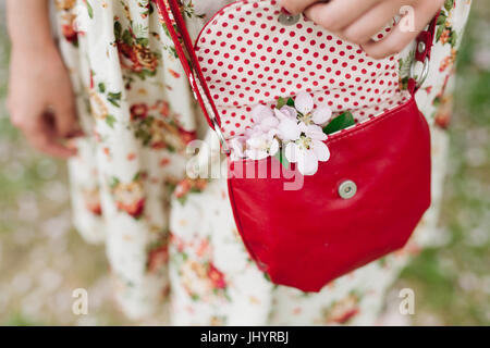 Tenue élégante. Close up of red sac à main en cuir matelassé en mains de femme élégante. Fille dans la rue à la mode. Journée ensoleillée. Conce mode féminine Banque D'Images