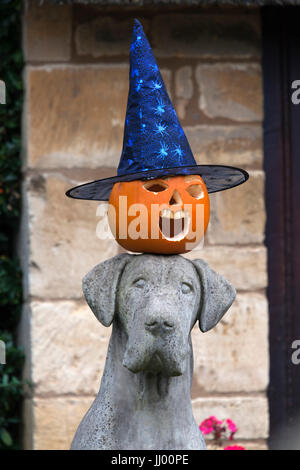 Masque d'Halloween Citrouille avec Chapeau de sorcière sur le dessus de la statue de chien, Royaume-Uni, Europe Banque D'Images