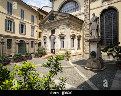 Milan. L'Italie. Entrée originale de la Biblioteca Ambrosiana sur Piazza San Sepolcro, ouvert 1609, et statue du Cardinal Federico Borromeo (1564-1631) Banque D'Images