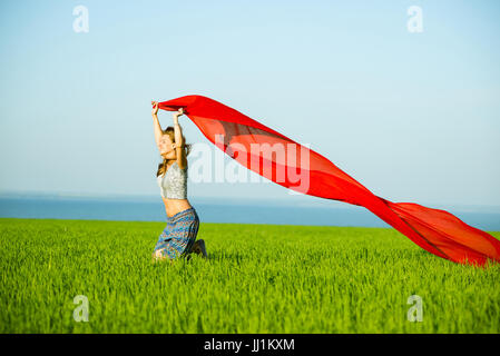 Jeune femme heureuse en champ de blé avec le tissu. Vie d'été Banque D'Images